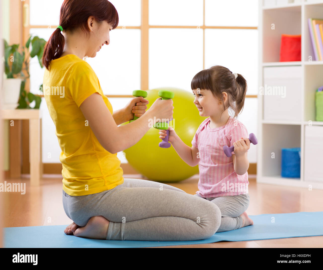 La madre e il figlio di lei figlia facendo esercizi di fitness con manubri Foto Stock