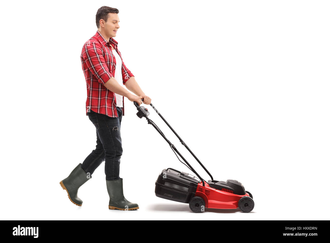 Lunghezza piena ripresa di profilo di un giardiniere falciatura con un tosaerba isolati su sfondo bianco Foto Stock