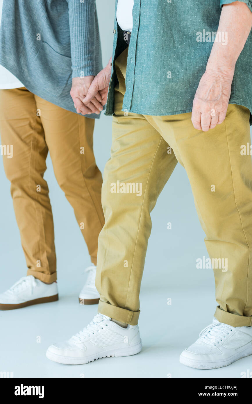 Vista parziale di coppia senior tenendo le mani mentre si cammina Foto Stock