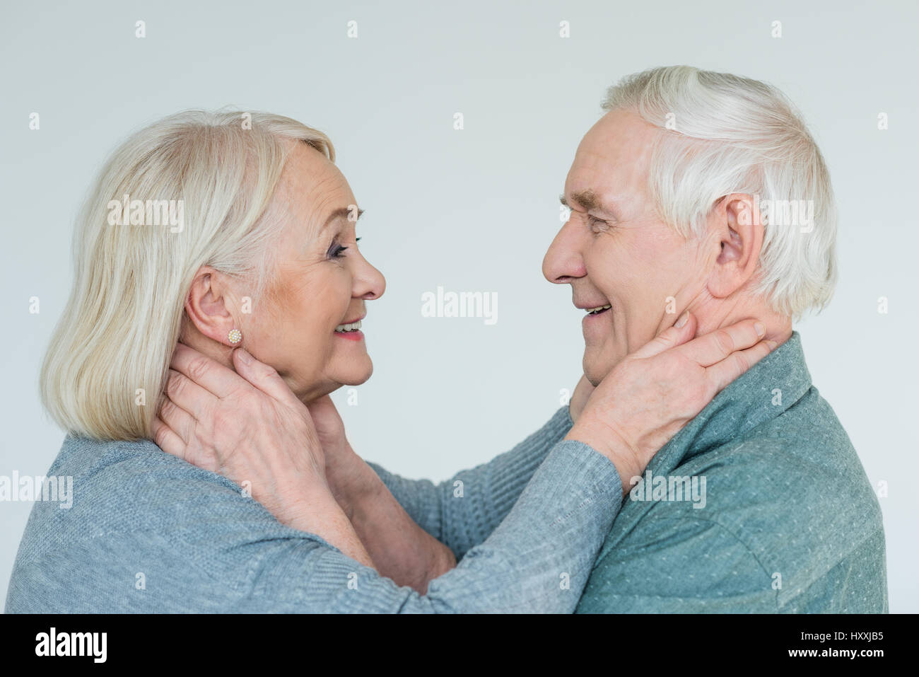 Vista laterale di sorridere coppia senior guardando ogni altro su bianco Foto Stock