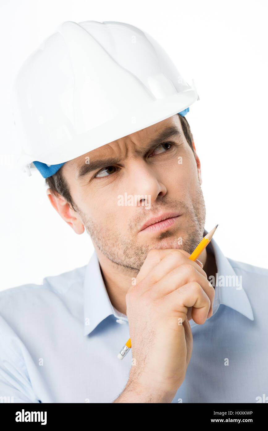 Riflessivo architetto maschio in hard hat holding matita su bianco Foto Stock