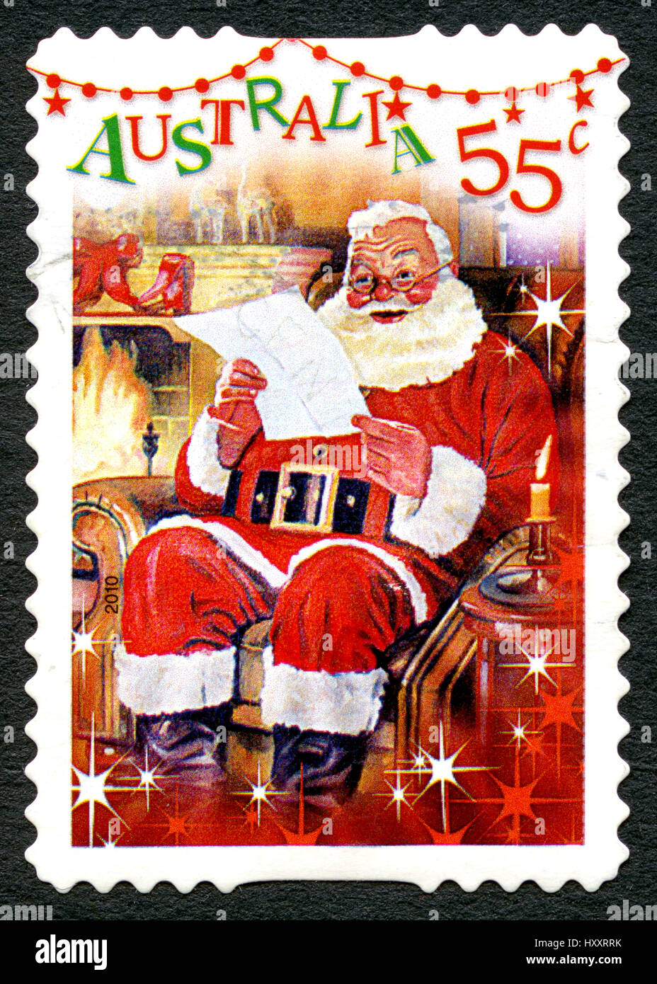 AUSTRALIA - circa 2010: utilizzate un francobollo da Australia, raffigurante una scena di festa di Santa Claus la lettura di una lettera da parte del camino, circa 2010. Foto Stock