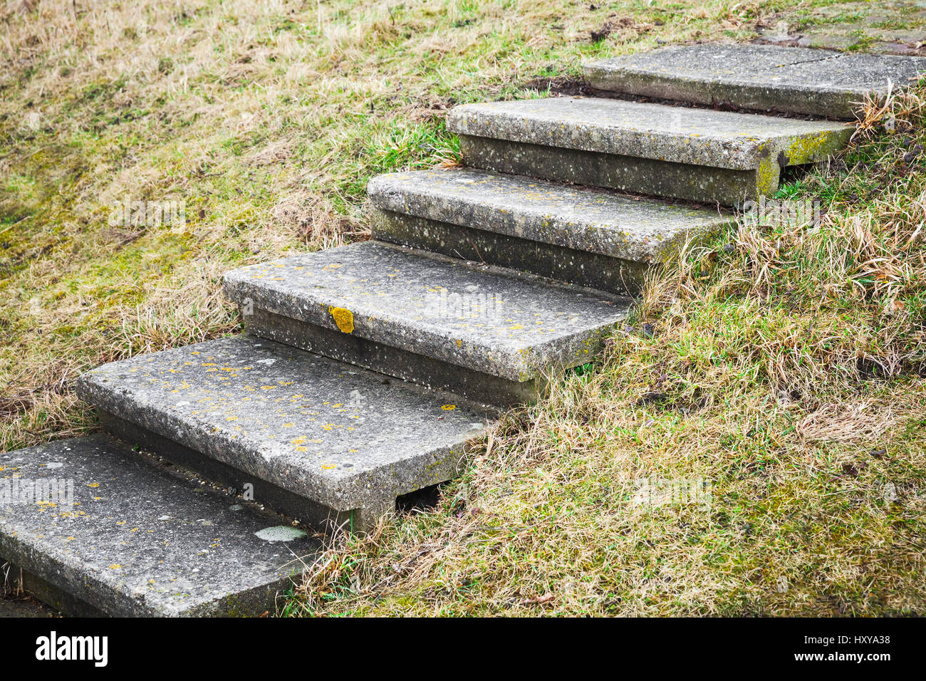 Vecchia scalinata in cemento va oltre l'erba verde collina Foto Stock