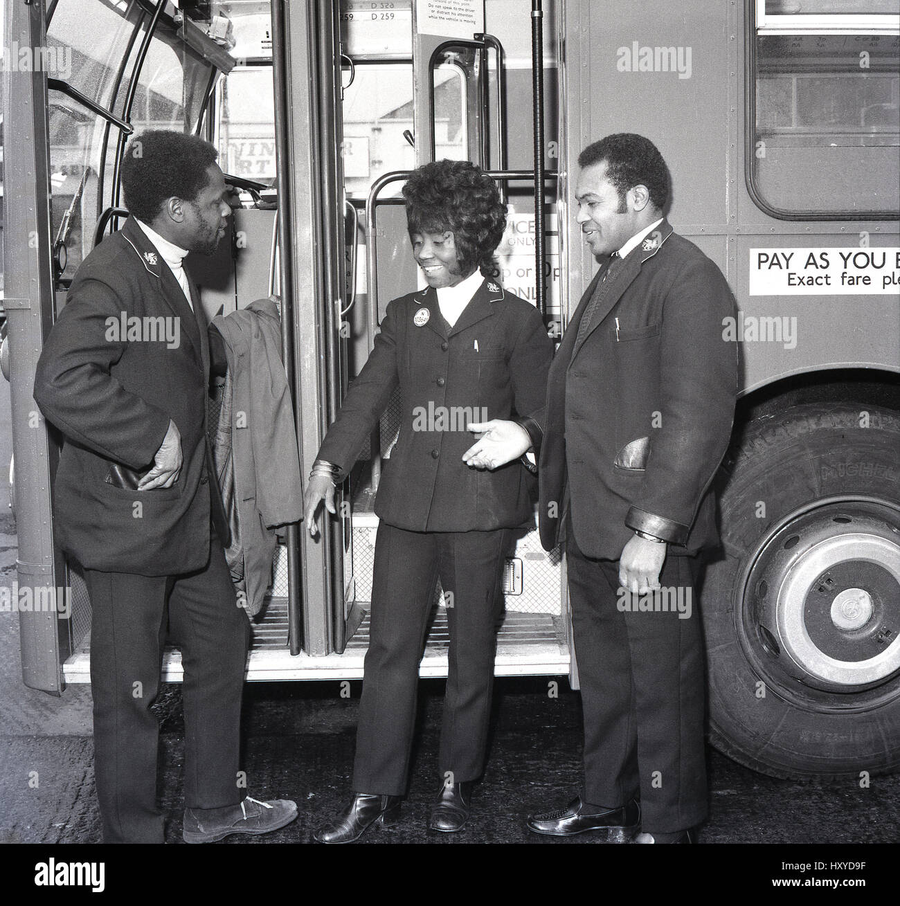 Anni Settanta, storico, tre autobus equipaggio di origine caraibica, chat assieme al di fuori di un bus, New Cross deposito autobus, Lewisham, nel sud di Londra, Inghilterra. Regno Unito. Foto Stock