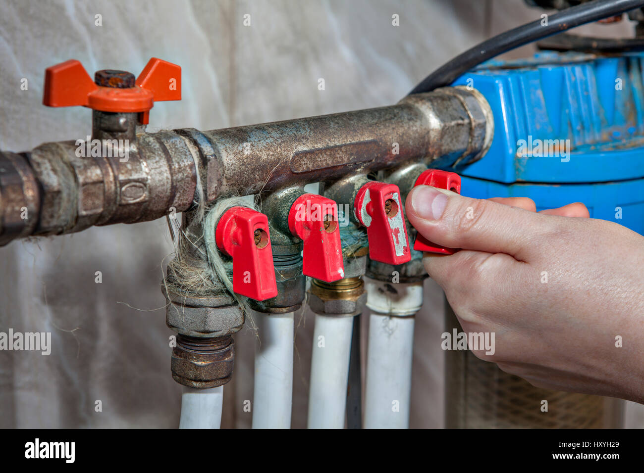 Per uso domestico di acqua di alimentazione, unità di distribuzione di acqua sanitaria sistema di alimentazione valvole, bloccando l'accesso alle tubazioni di acqua, girando a mano il rubinetto della valvola. Foto Stock