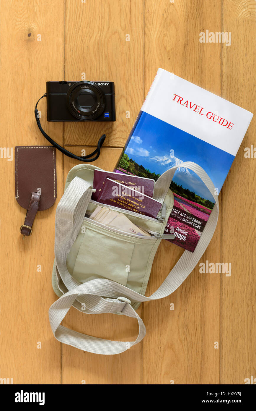 Holiday preparazione e pianificazione, con cinghia di denaro, una videocamera e un libro guida. Foto Stock