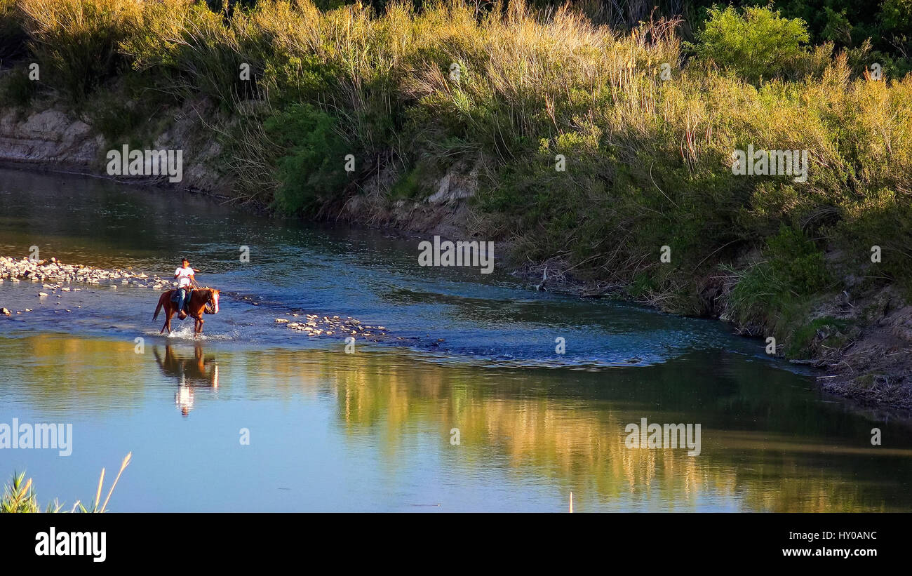 Uomo messicano sul cavallo attraverso il fiume Rio Grande parco nazionale di Big Bend Foto Stock