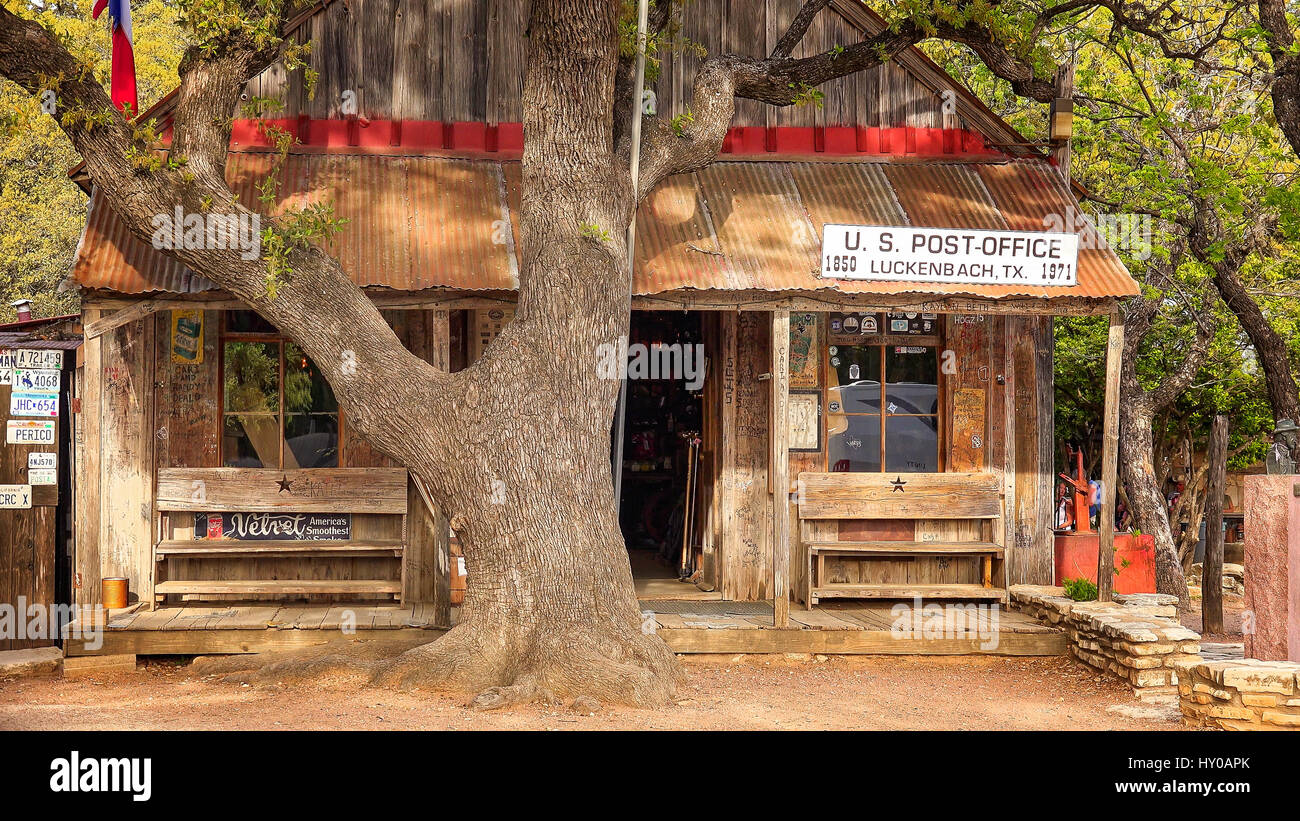 Una donna cammina davanti a un edificio in Luckenbach Texas che serve come le città post office, negozio e bar Foto Stock