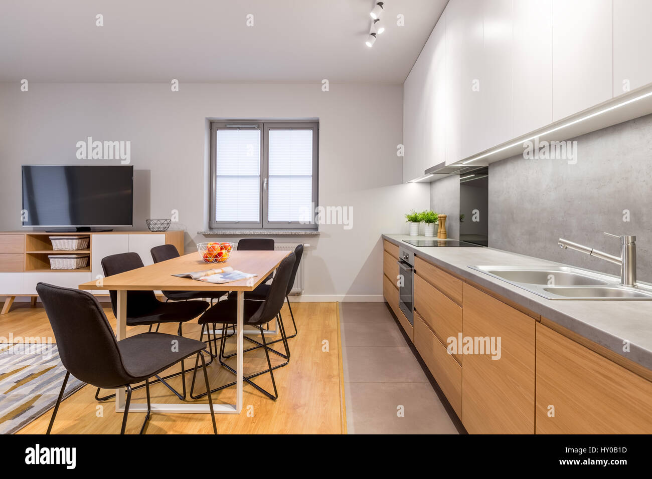 Casa moderna interno con cucina in legno, tavolo e credenza dei pannelli del pavimento Foto Stock