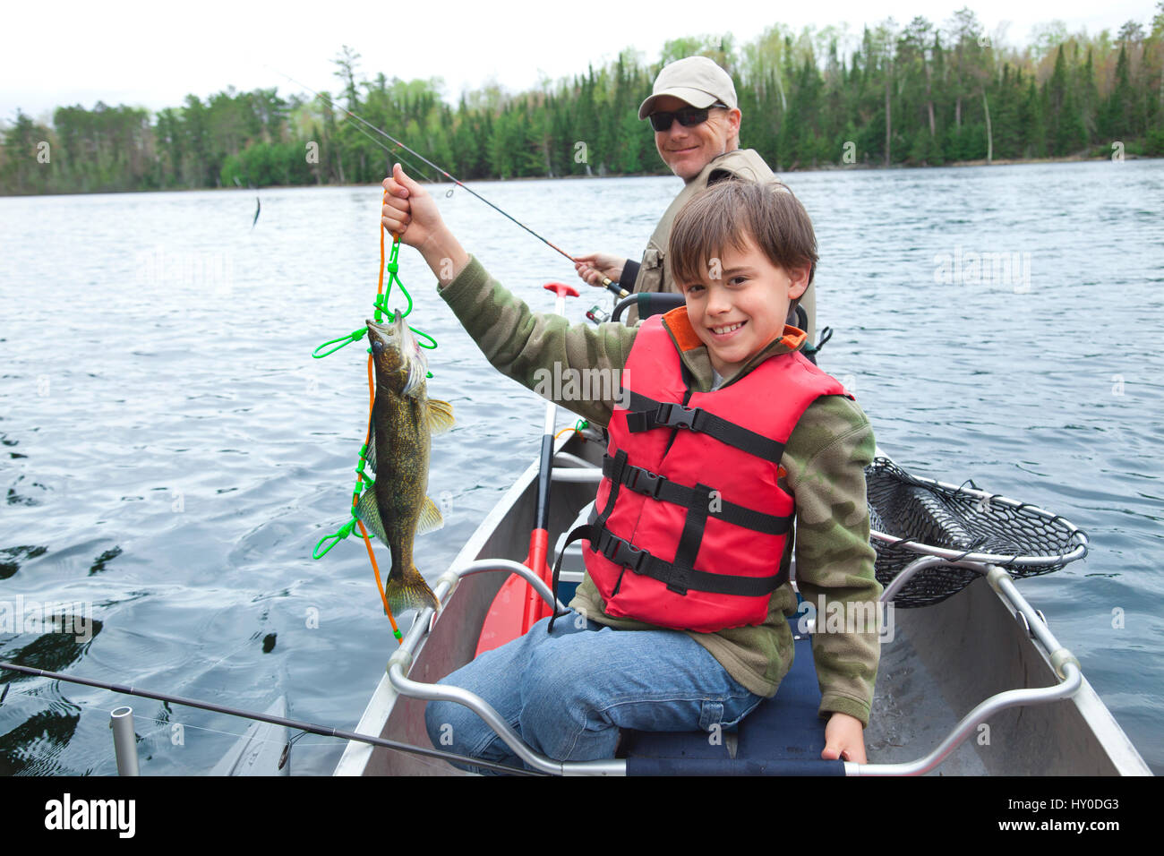 Un giovane pescatore caucasica orgogliosamente tiene il suo primo walleye della giornata Foto Stock