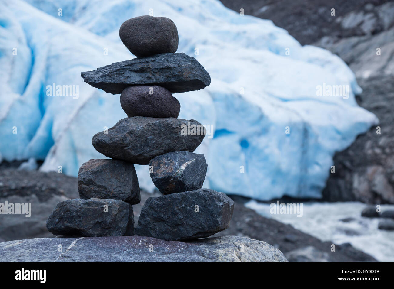 Un tumulo costruito su una roccia nel recessional morena del ghiacciaio orso appare come una piccola persona. La pila di rocce scure è contrastato dal luminoso Foto Stock