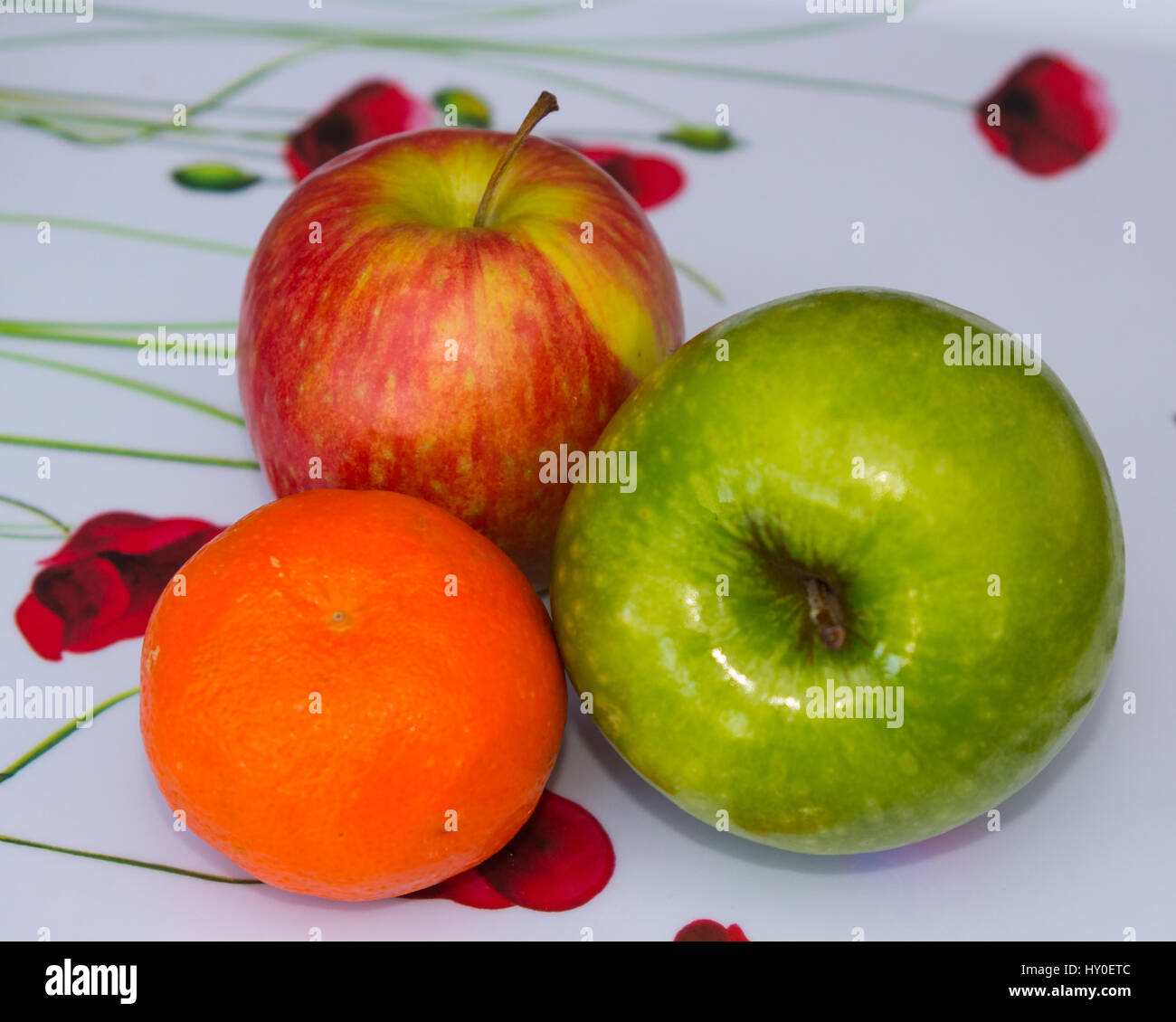 Questa piccola selezione di frutta comprendenti due mele e un piccolo mandarino che sono parte di un settimanale il negozio di drogheria fornisce un elemento essenziale o Foto Stock