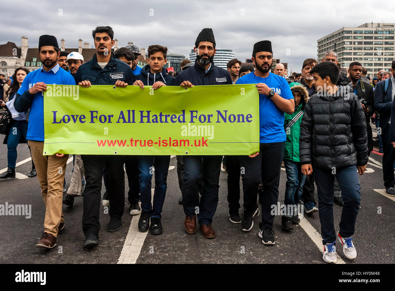 Una settimana dopo il terrore di Londra attacco, i membri della Comunità Musulmana a piedi attraverso Westminster Bridge con striscioni denunciando l attentato di Londra, Regno Unito Foto Stock