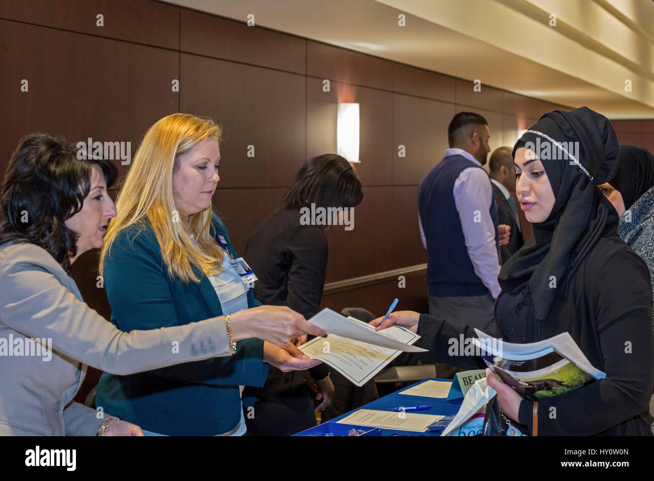 Dearborn, Michigan - Selezionatori per Beaumont Hospital di parlare a un lavoro seekeer a una fiera del lavoro sponsorizzato da accesso, la Comunità Araba centro economico Foto Stock