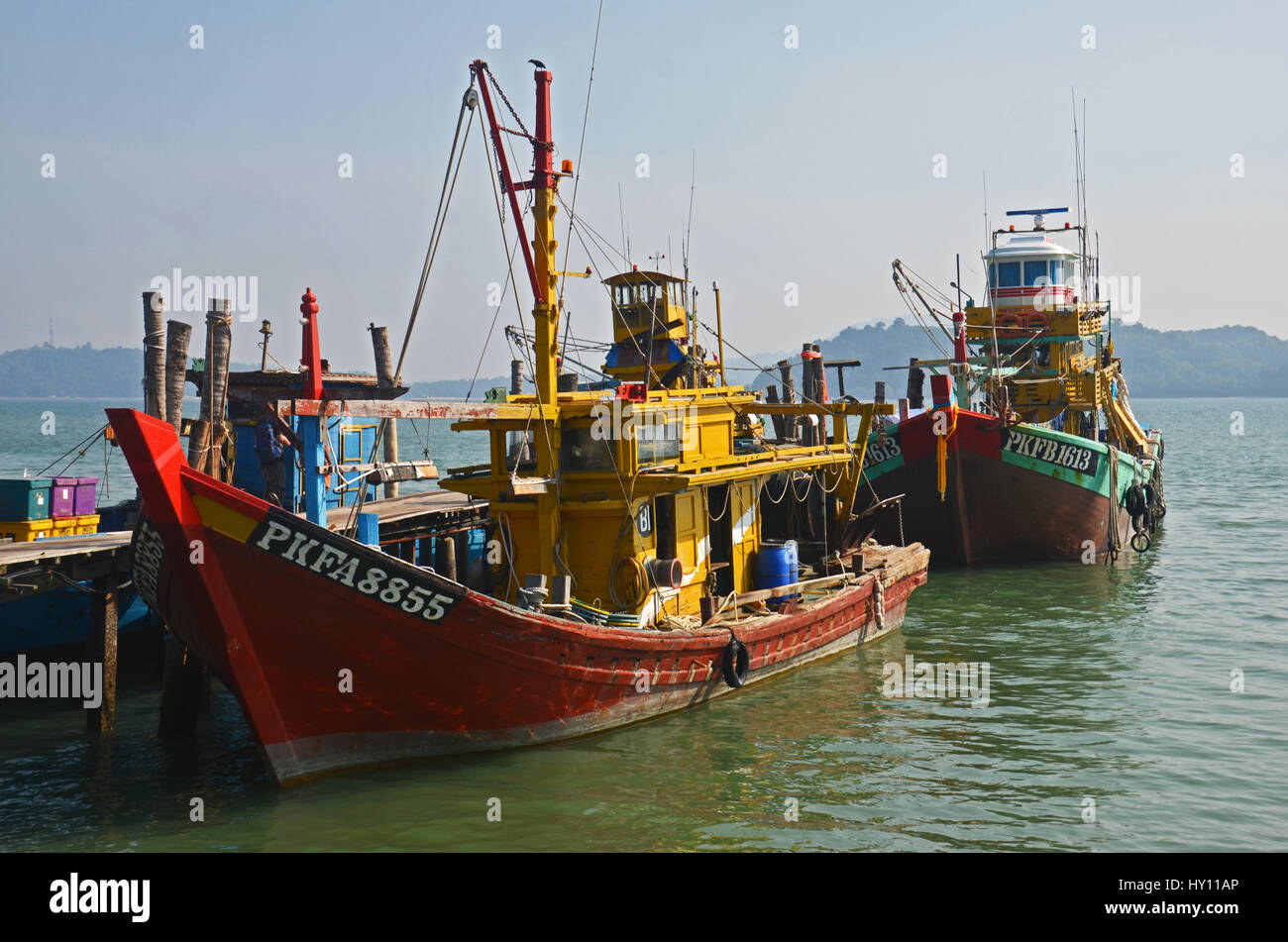 Coloratissime barche di pescatori ormeggiate presso un pontile sulla Isola di Pangkor, Malaysia Foto Stock