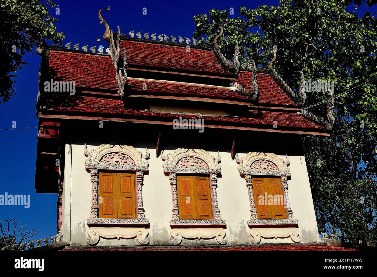 Lamphun, Tailandia - 28 dicembre 2012: la bella biblioteca con la sua capanna orange i tetti di tegole e distintivo di bird-simili ornamenti chofah al Wat Doi Foto Stock