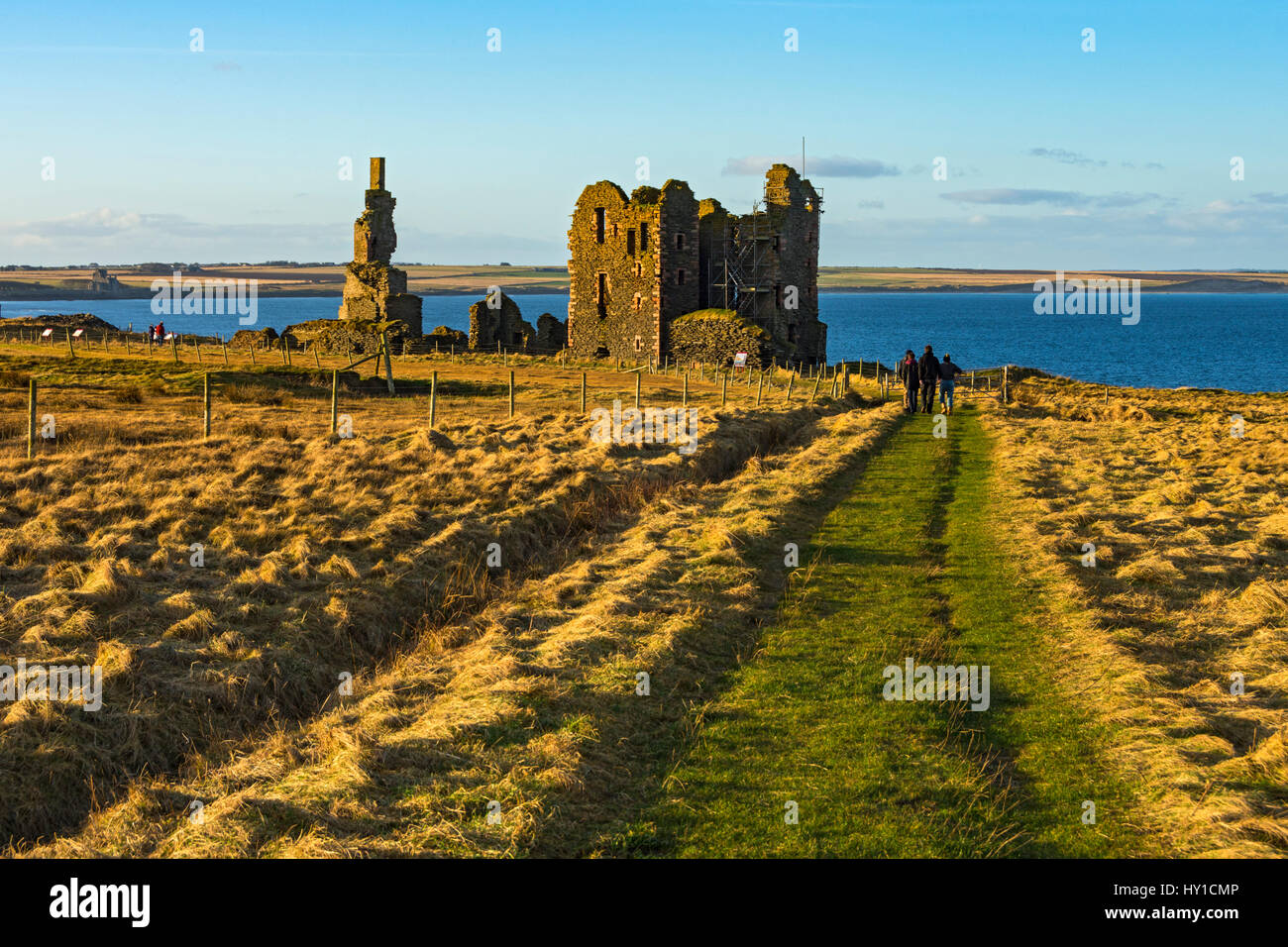 Walkers avvicinando Castello Sinclair Girnigoe, Noss Testa, vicino a Wick, Caithness in Scozia, Regno Unito Foto Stock