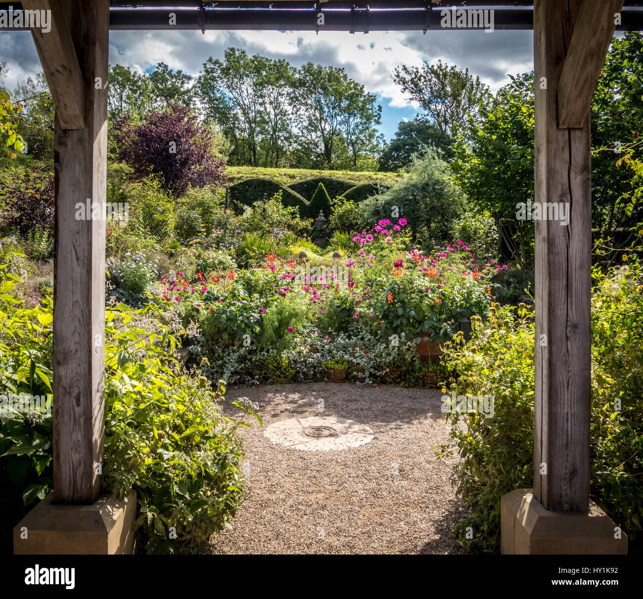 Formale giardino misti semina con copertura topiaria da visto attraverso la struttura in legno. Foto Stock