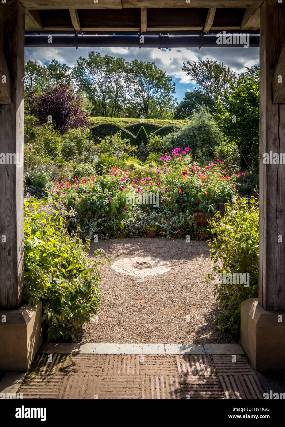 Formale giardino misti semina con copertura topiaria da visto attraverso la struttura in legno. Foto Stock