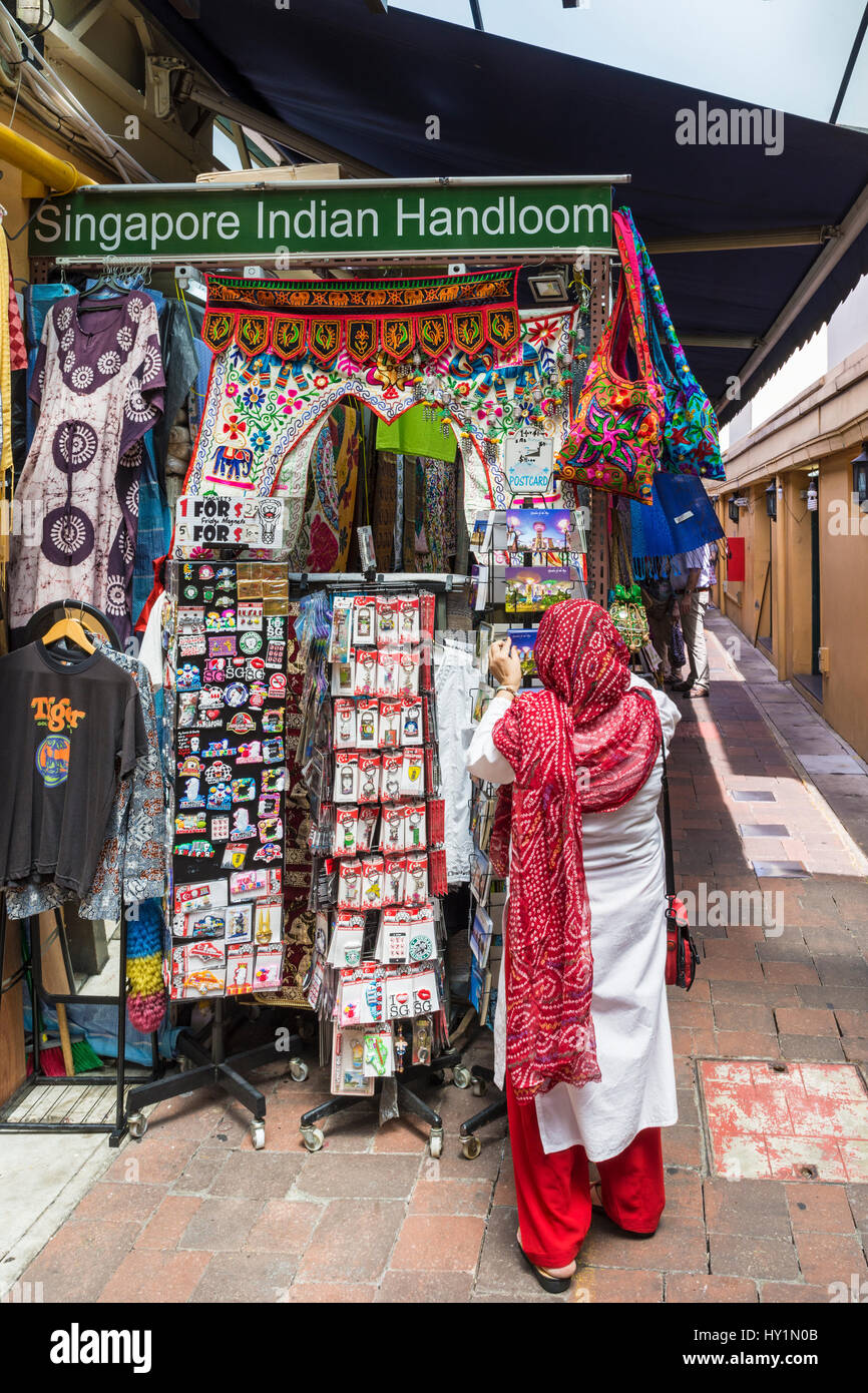 Titolare di stallo tende ad i suoi prodotti per la vendita in Little India Arcade, Little India, Singapore Foto Stock