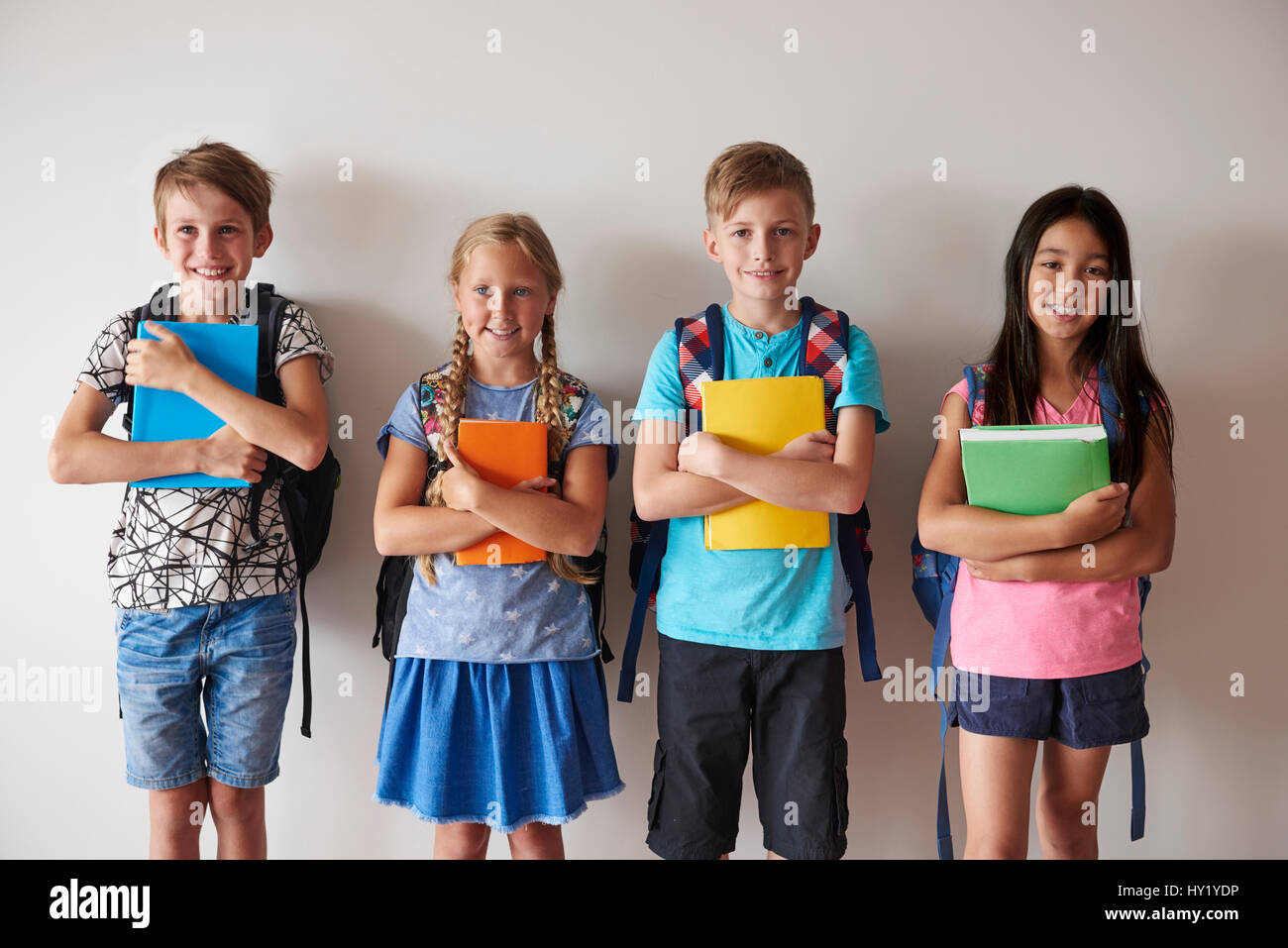 Quattro ragazzi smiley azienda libri Foto Stock