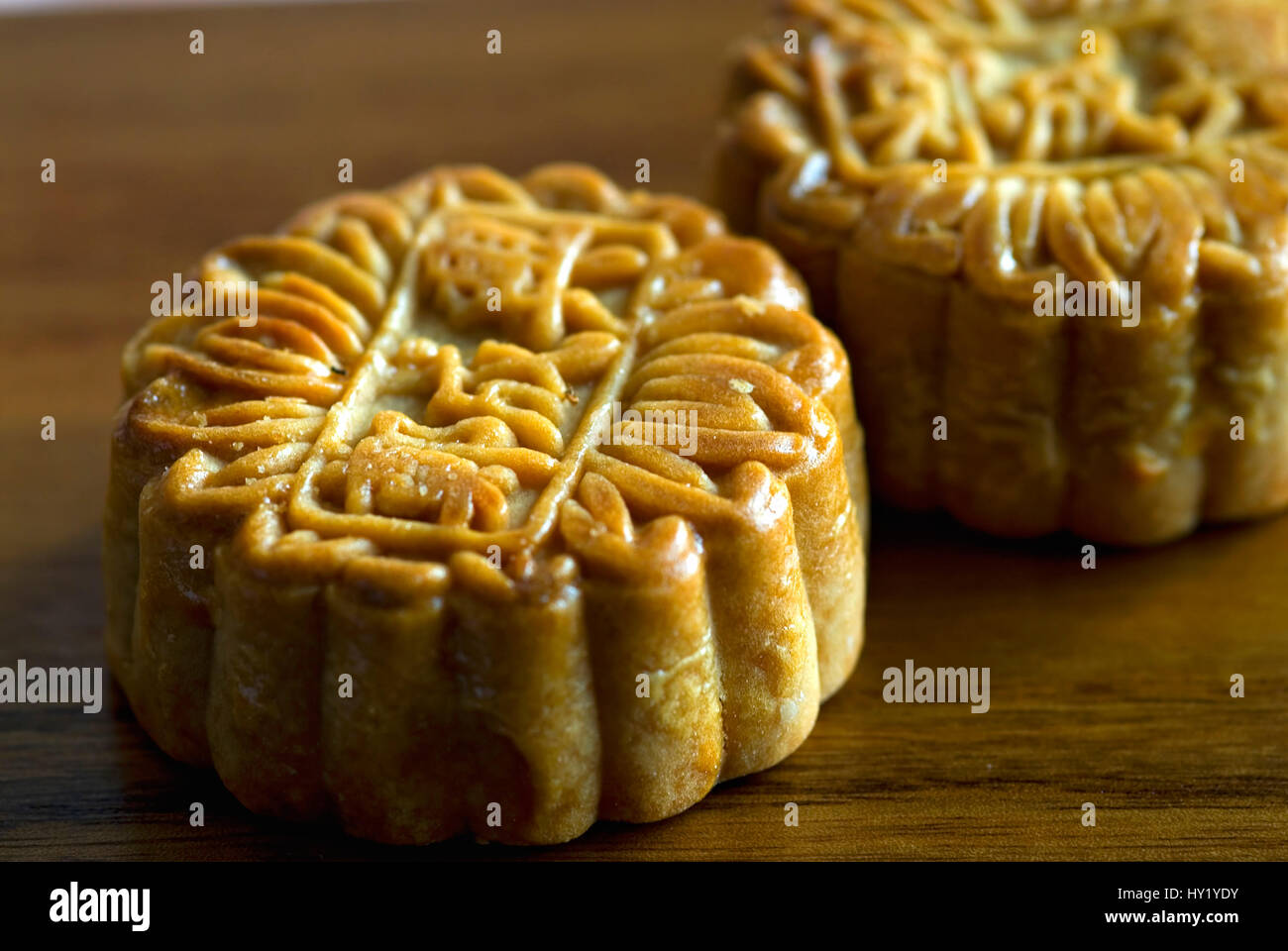 Questa macro stock foto mostra una tipica forma cubica dolci Cinesi su una piastra woode. Sulla parte superiore sono i caratteri cinesi sono state formate nella dolce. Foto Stock