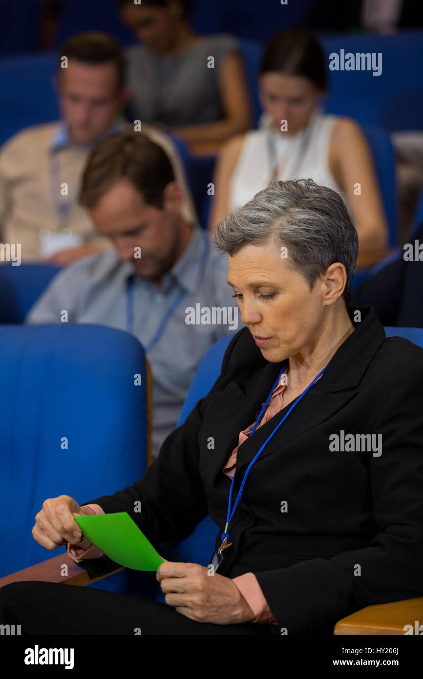Business executive guardando al green card presso il centro conferenze Foto Stock