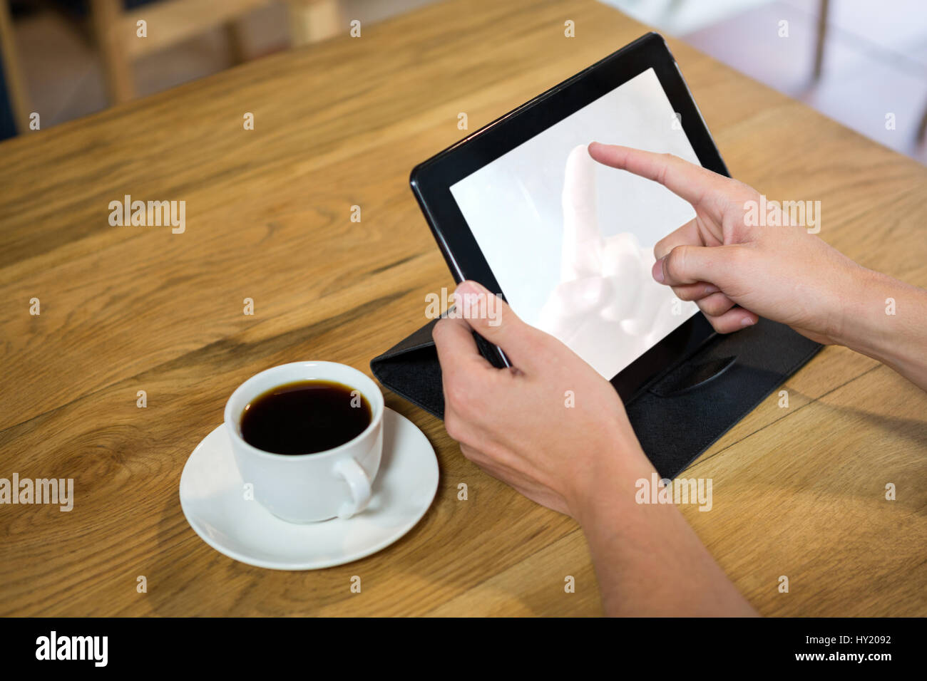 Close-up di giovane uomo con tavoletta digitale con schermo vuoto in coffee shop Foto Stock