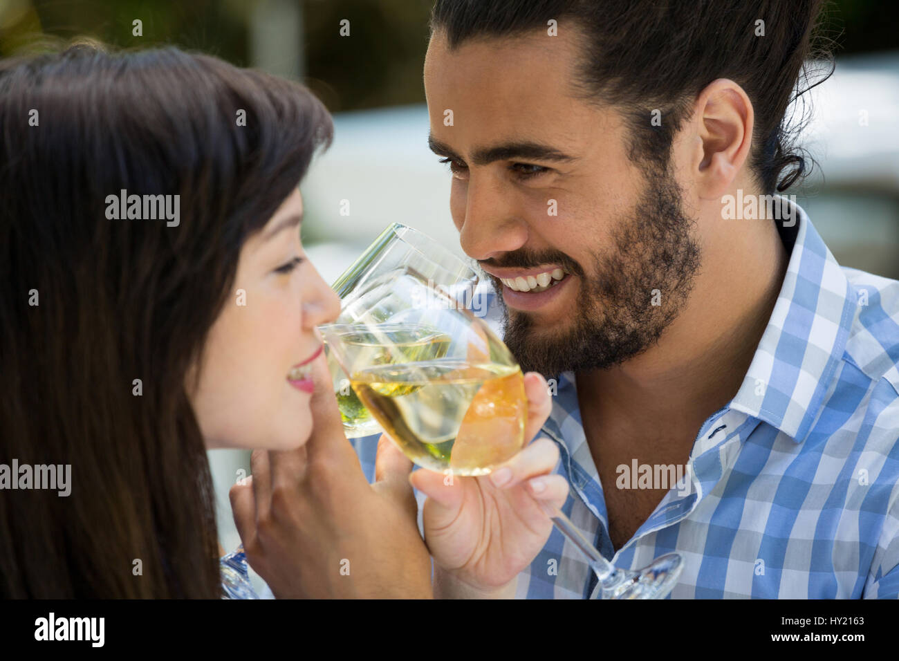 Amare giovane uomo e donna bere il vino in posizione di parcheggio Foto Stock