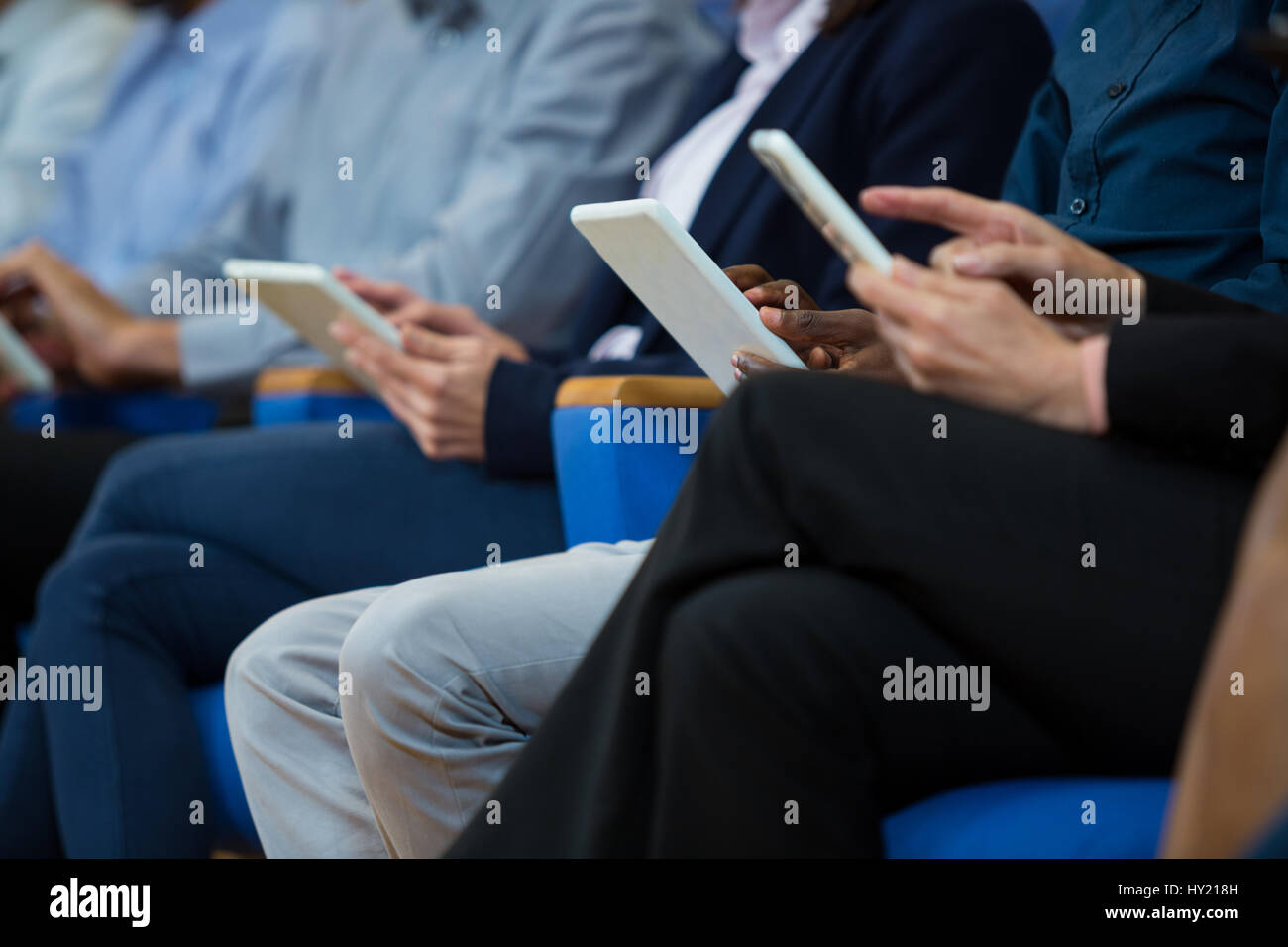 I dirigenti aziendali che partecipano a una riunione di affari con tavoletta digitale presso il centro conferenze Foto Stock