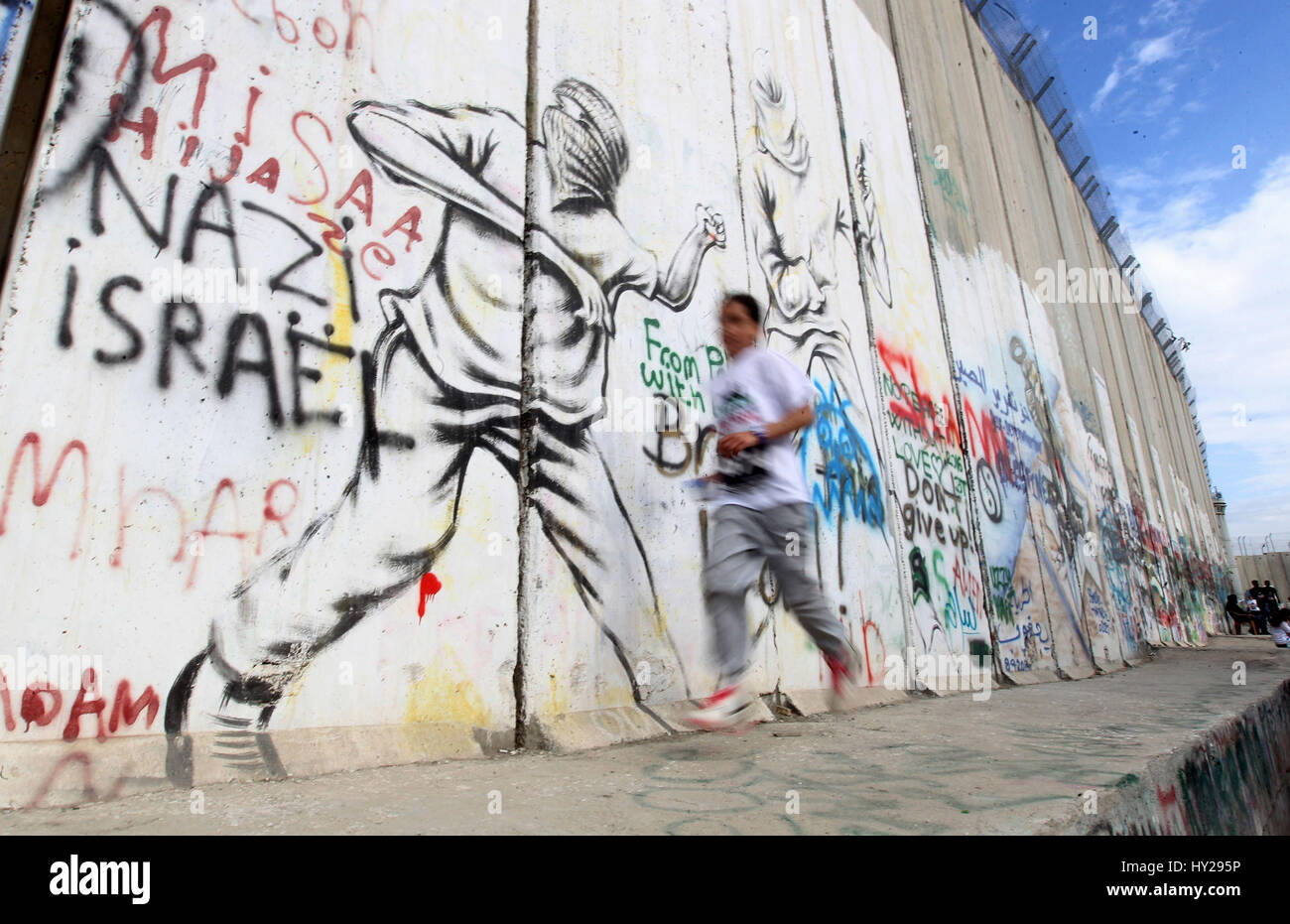 Betlemme, West Bank, Territorio palestinese. 31 Mar, 2017. I partecipanti eseguono lungo Israele la controversa barriera di separazione che divide la Cisgiordania da Gerusalemme, in biblico della Cisgiordania città di Betlemme durante il quinto Palestina Maratona il Marzo 31, 2017 Credit: Wisam Hashlamoun APA/images/ZUMA filo/Alamy Live News Foto Stock