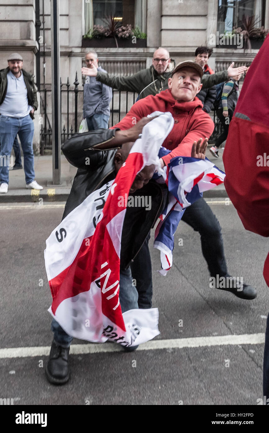 Londra, Regno Unito. Il 1 aprile, 2017. Un anti-fascista viene attaccato violentemente mentre si tenta di prendere una bandiera nazionalista da un'estrema destra EDL stati(rosso in alto) durante un contatore-protestare contro di estrema destra gruppi marciando attraverso Westminster. © Guy Corbishley/Alamy Live News Foto Stock