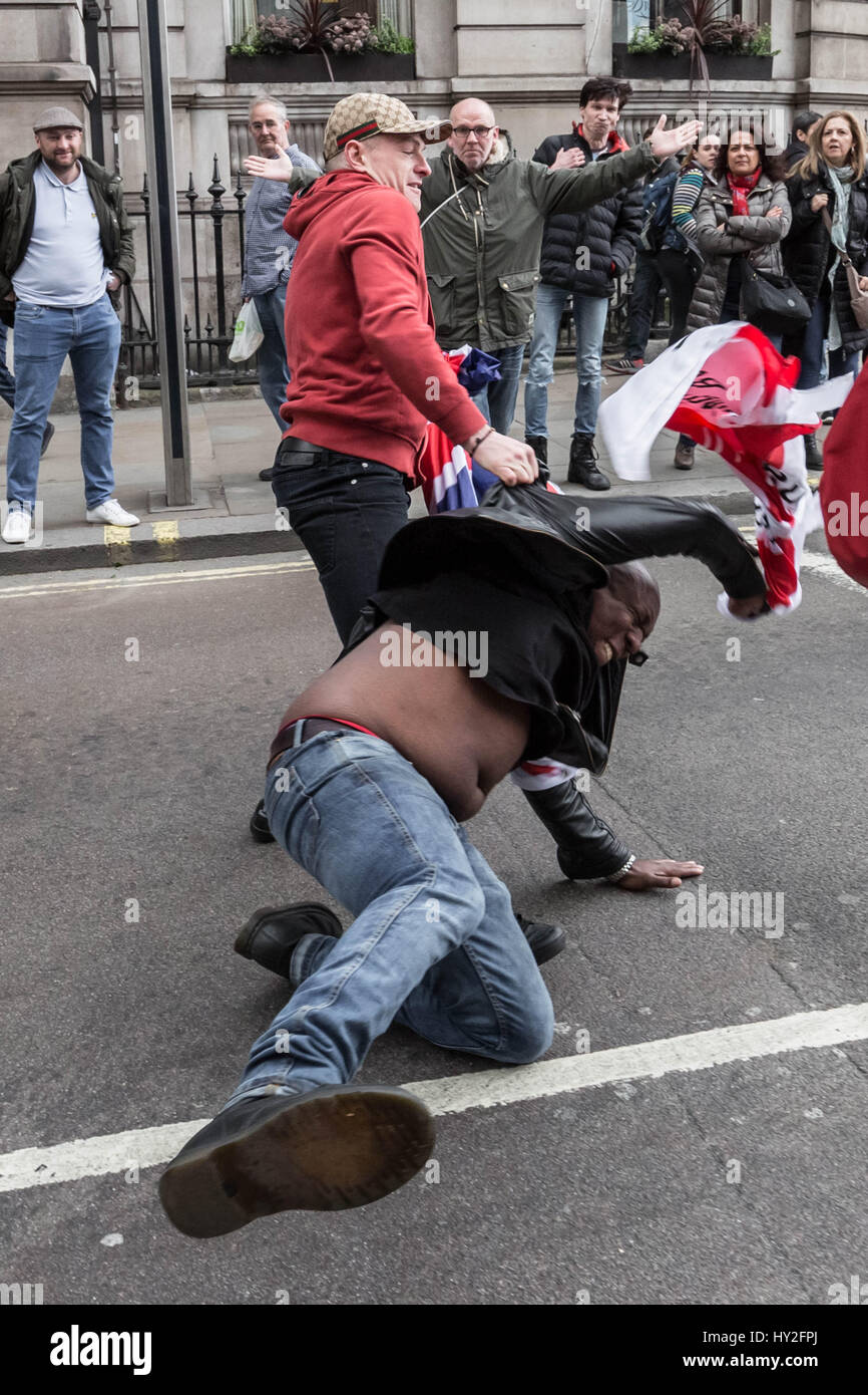 Londra, Regno Unito. Il 1 aprile, 2017. Un anti-fascista viene attaccato violentemente mentre si tenta di prendere una bandiera nazionalista da un'estrema destra EDL stati(rosso in alto) durante un contatore-protestare contro di estrema destra gruppi marciando attraverso Westminster. © Guy Corbishley/Alamy Live News Foto Stock