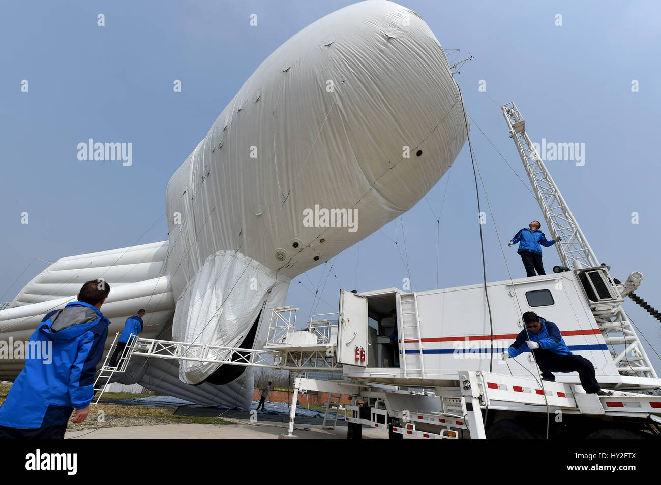 (170401) -- LIU AN, 1 aprile 2017 (Xinhua) -- i membri dello staff gonfiare un pallone frenato in un terreno di prova in Liu'an, Cina orientale della provincia di Anhui, Marzo 29, 2017. Il pallone frenato è una piattaforma aerea il trasporto di vari dispositivi, come avvertimento radar, apparecchiature di sorveglianza, nebbia dei dispositivi di rilevamento, relè di comunicazione i dispositivi e le apparecchiature di imaging. Il palloncino è destinato a svolgere un ruolo di precauzione e di rilevamento, la vigilanza ambientale, di sicurezza e di monitoraggio dei sistemi di protezione. (Xinhua/Guo Chen) (lfj) Foto Stock