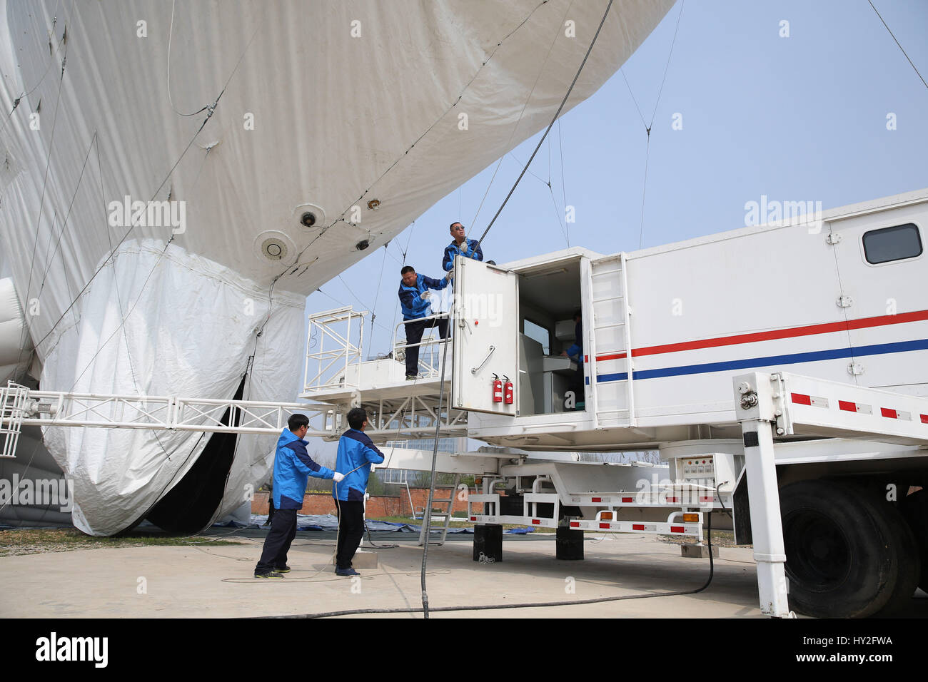 (170401) -- LIU AN, 1 aprile 2017 (Xinhua) -- i membri dello staff regolare la direzione di un pallone frenato in un terreno di prova in Liu'an, Cina orientale della provincia di Anhui, Marzo 29, 2017. Il pallone frenato è una piattaforma aerea il trasporto di vari dispositivi, come avvertimento radar, apparecchiature di sorveglianza, nebbia dei dispositivi di rilevamento, relè di comunicazione i dispositivi e le apparecchiature di imaging. Il palloncino è destinato a svolgere un ruolo di precauzione e di rilevamento, la vigilanza ambientale, di sicurezza e di monitoraggio dei sistemi di protezione. (Xinhua/Cheng Tingting) (lfj) Foto Stock