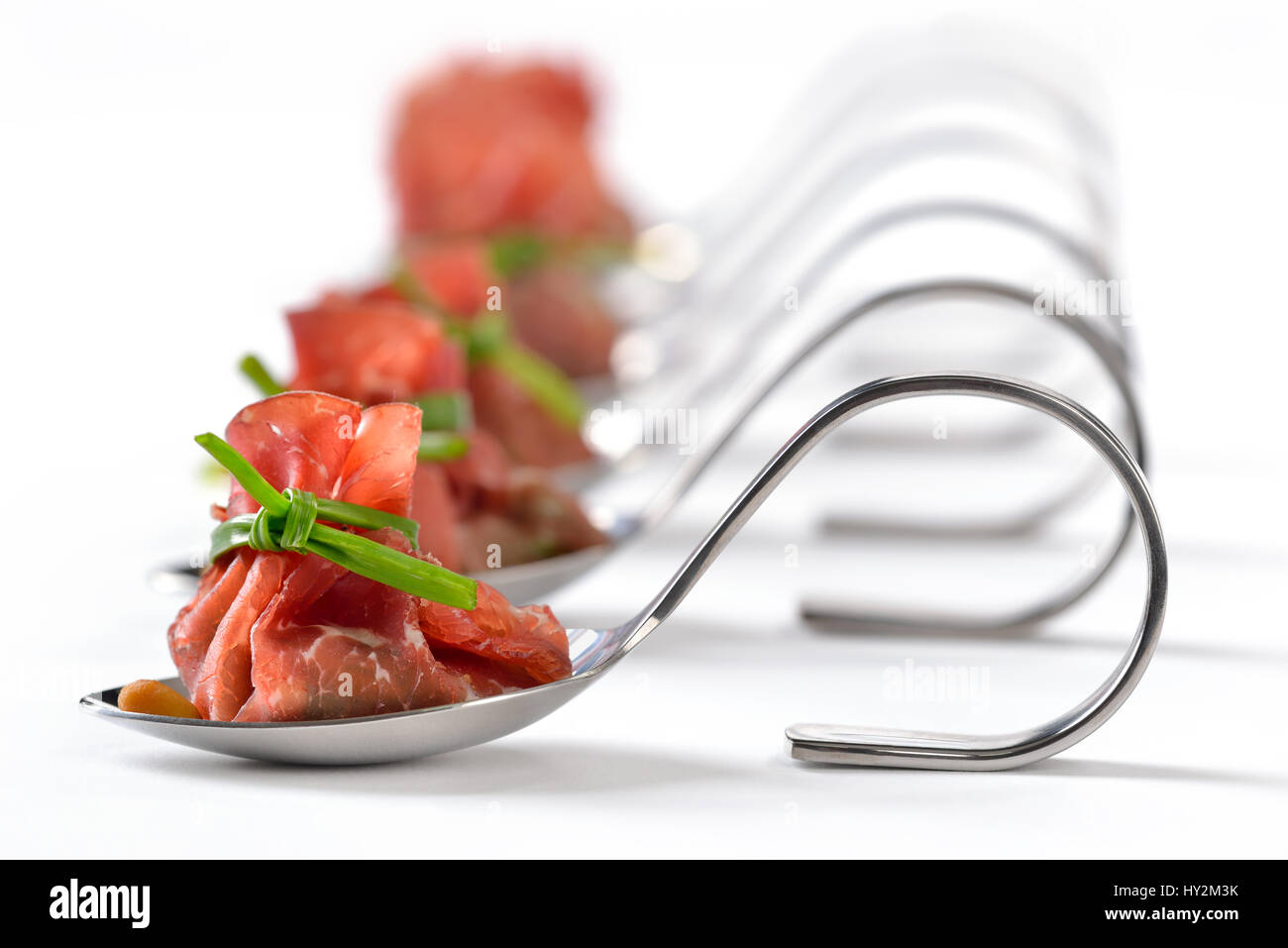 Deliziosa aria-carni bovine essiccate ham - Italiano la bresaola - farcite con un trito di scosso insalata, arrosto di pinoli, parmigiano e cremoso di aceto balsamico Foto Stock