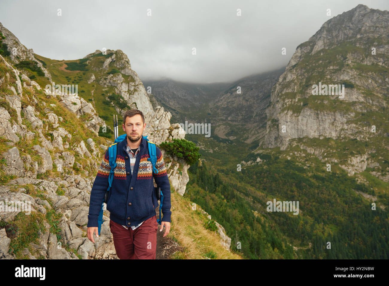 Lone uomo trekking sul sentiero roccioso in montagna Foto Stock