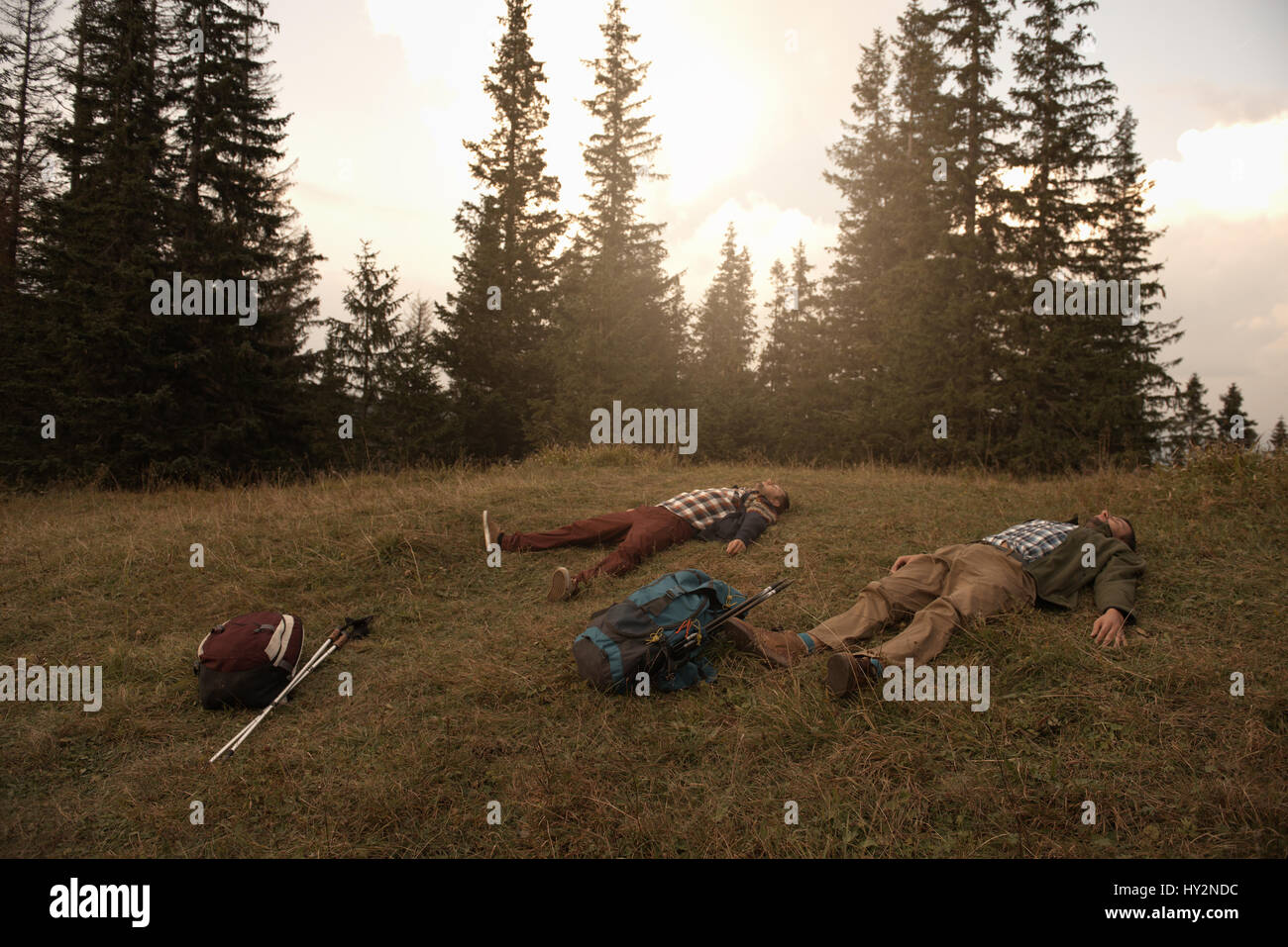 Gli escursionisti stanchi sdraiati sull'erba dopo un trek Foto Stock