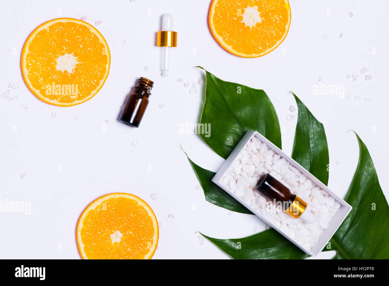 Il Branding mock-up. Olio essenziale naturale, bottiglia di cosmetici contenitori con fettine di arancia. Foto Stock