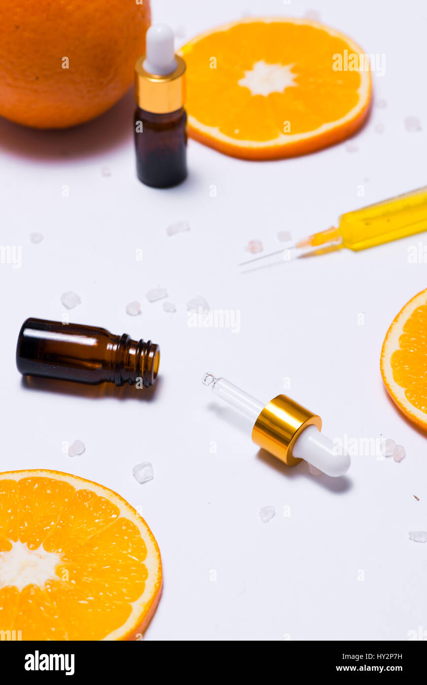 Il Branding mock-up. Olio essenziale naturale, bottiglia di cosmetici contenitori con fettine di arancia. Foto Stock