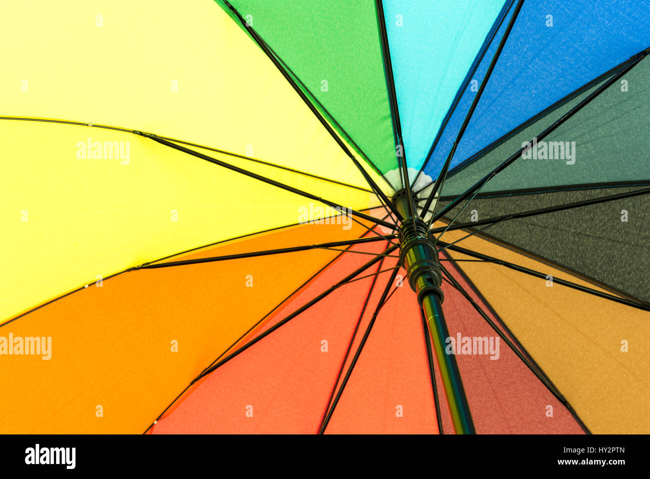 Colorato ombrello che proteggerà il suo utente da pioggia sotto il rainbow segmenti colorati Foto Stock