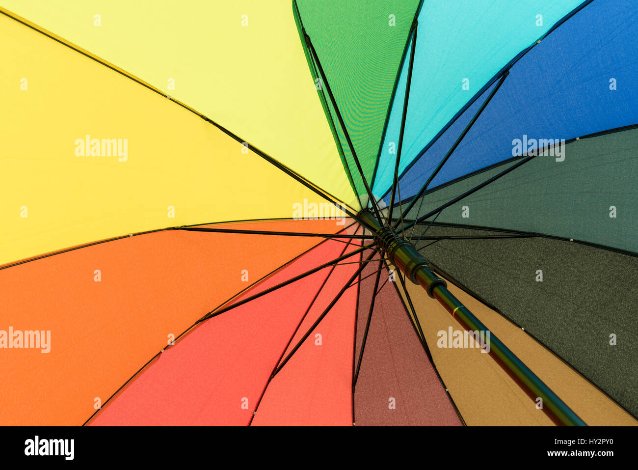 Colorato ombrello che proteggerà il suo utente da pioggia sotto il rainbow segmenti colorati Foto Stock