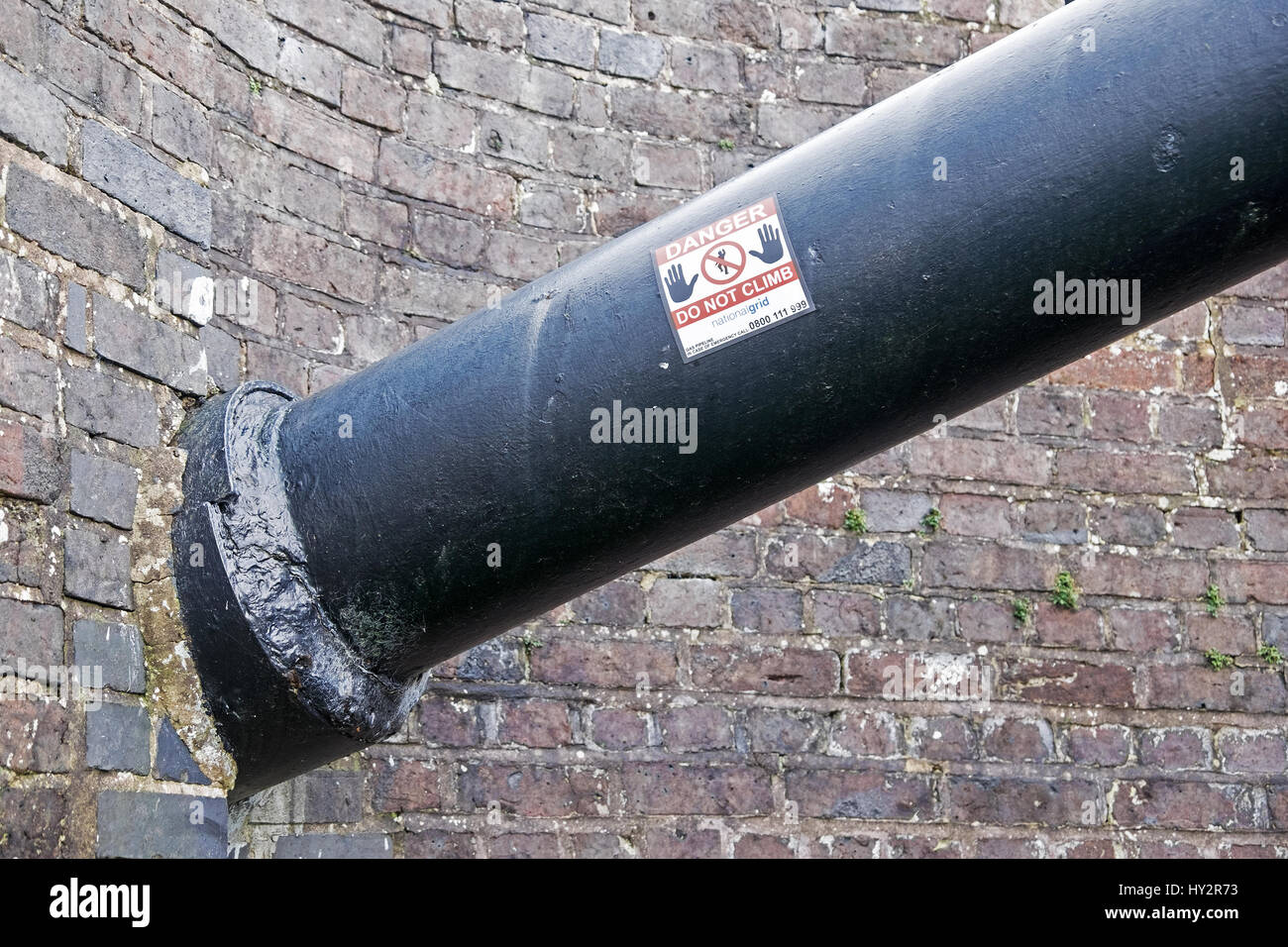 Un Tubo verniciato con anti-vandalo di vernice e un adesivo dicendo pericolo non salire Foto Stock