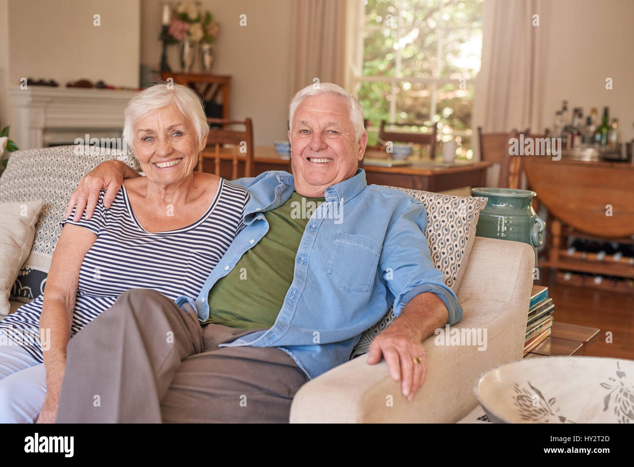 Coppia senior contenuti a casa sul loro divano Foto Stock