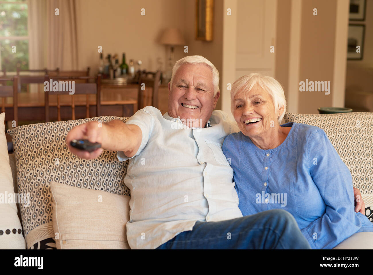 Ridendo coppia senior di guardare la televisione a casa Foto Stock