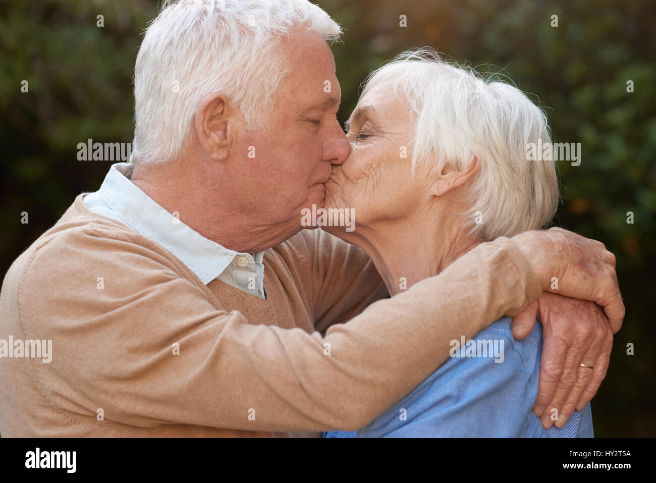 Affettuosa di anziani in amore abbracciando e baciando all'aperto Foto Stock