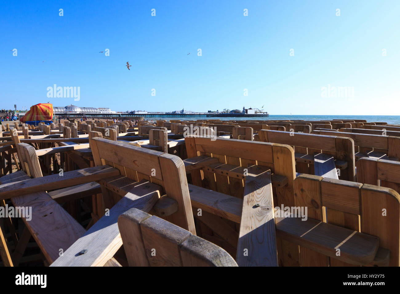 Tavoli in legno e sedie impilate ese ebeachfront in Brighton, East Sussex, Inghilterra Foto Stock