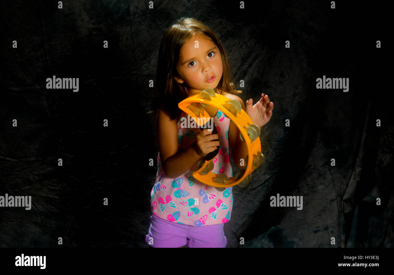 Ragazza giovane con tamburello in studio di impostazione Foto Stock