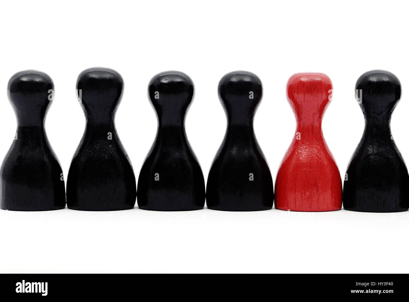 Gioco rosso figura nel bel mezzo del gioco nero figure, Rote Spielfigur inmitten von schwarzen Spielfiguren Foto Stock