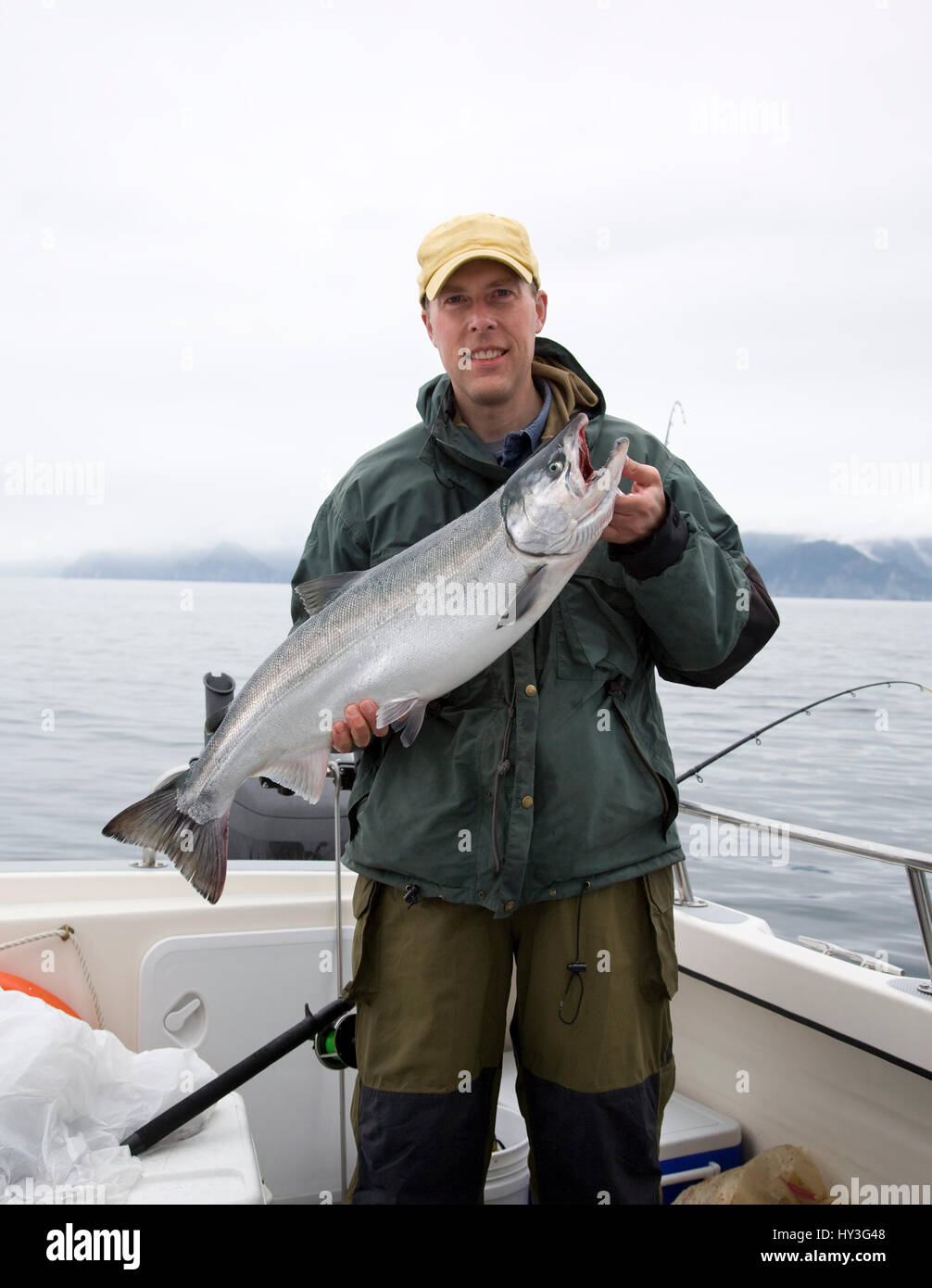 Un felice pescatore in Alaska può contenere fino a appena pescato salmone argento Foto Stock